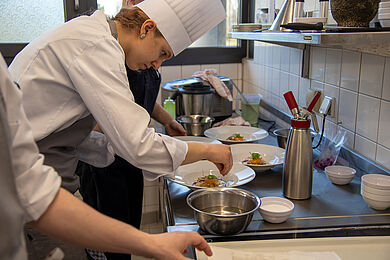 Azubis beim Anrichten der Speisen