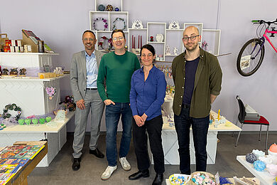Gruppenfoto im Ladengeschäft Elsterkammer, v.l. Tobias Schmidt in einem hellgrauen Anzug, Martin Meißner in Jeans und einem grünen Pullover, Christin Melcher in einer blauen Bluse und schwarzer Hose und Dr. Frank Braun in einer dunklen Hose und einem grünen Hemd.