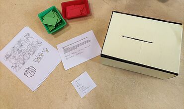 Wahlurneund Abstimmungszettel in Grün und Rot