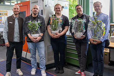 5 Personen nebeneinander. die 4 rechten halten Blumen in den Händen