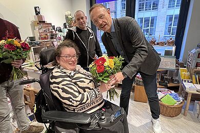 Tobias Schmidt übergibt einen Blumenstrauß