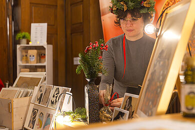 Junge Frau an ihrem Stand im Historischen Saal