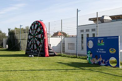 Auf dem Gelände steht eine große Dartscheibe, die vor der Veranstaltung aufgeblasen wurde. Bälle mit einer rauen Oberfläche können an diese Dartscheibe geschossen werden und bleiben dort haften.