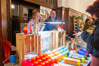 Verkaufsstand umani Kulturgut mit farbenfrohen Kerzen
