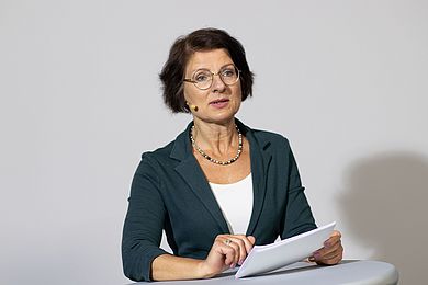 Dr. Grit Franke ist Geschäftsbereichsleiterin vom Berufsbildungswerk Leipzig. Sie spricht in ein Headset und trägt eine Brille mit feinem, silbernen Rahmen und eine Kette mit bunten Perlen.