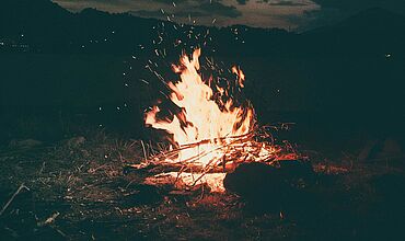 Feuer in dunkler Landschaft 