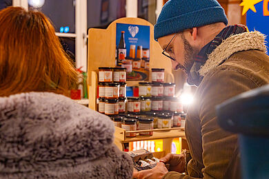 Besucher*innen an einem Stand mit Aufstrichen