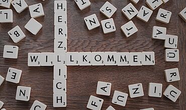 Scrabblebuchstaben Herzlich willkommen